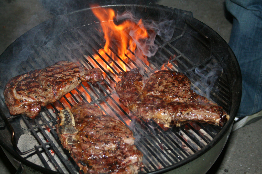 Steak cooking over a charcoal grill