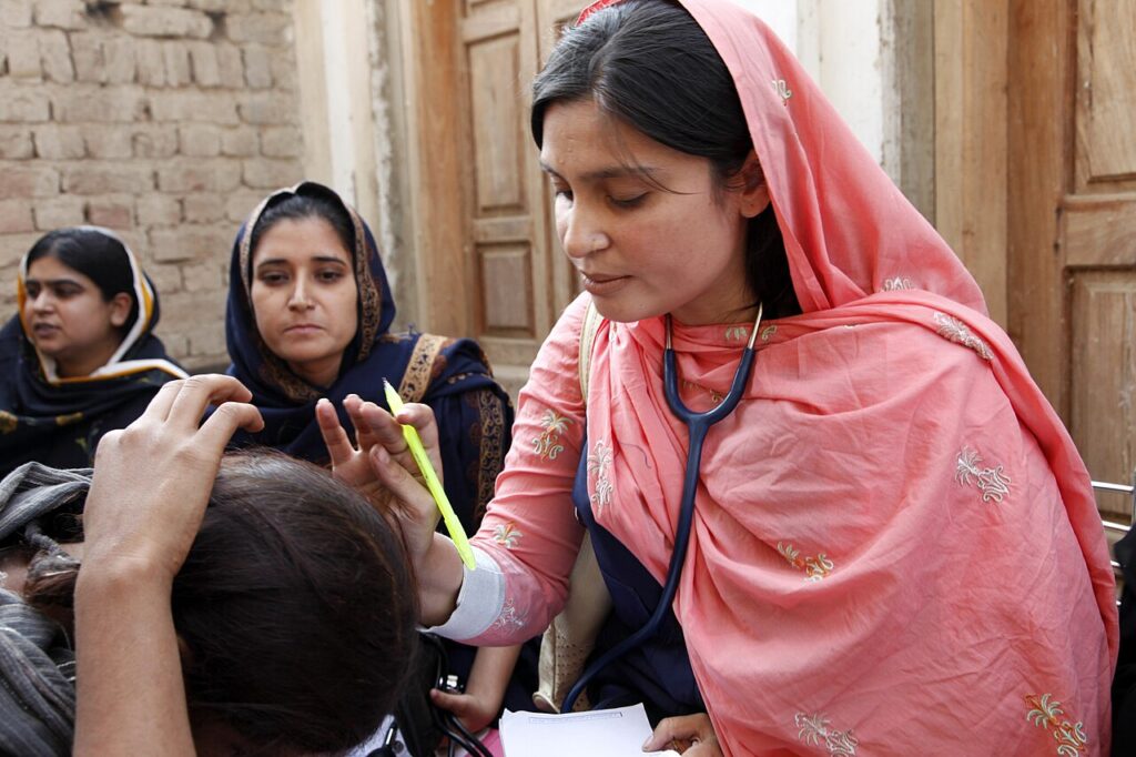 A woman doctor examines a patient at a mobile health clinic in Sindh, Pakistan