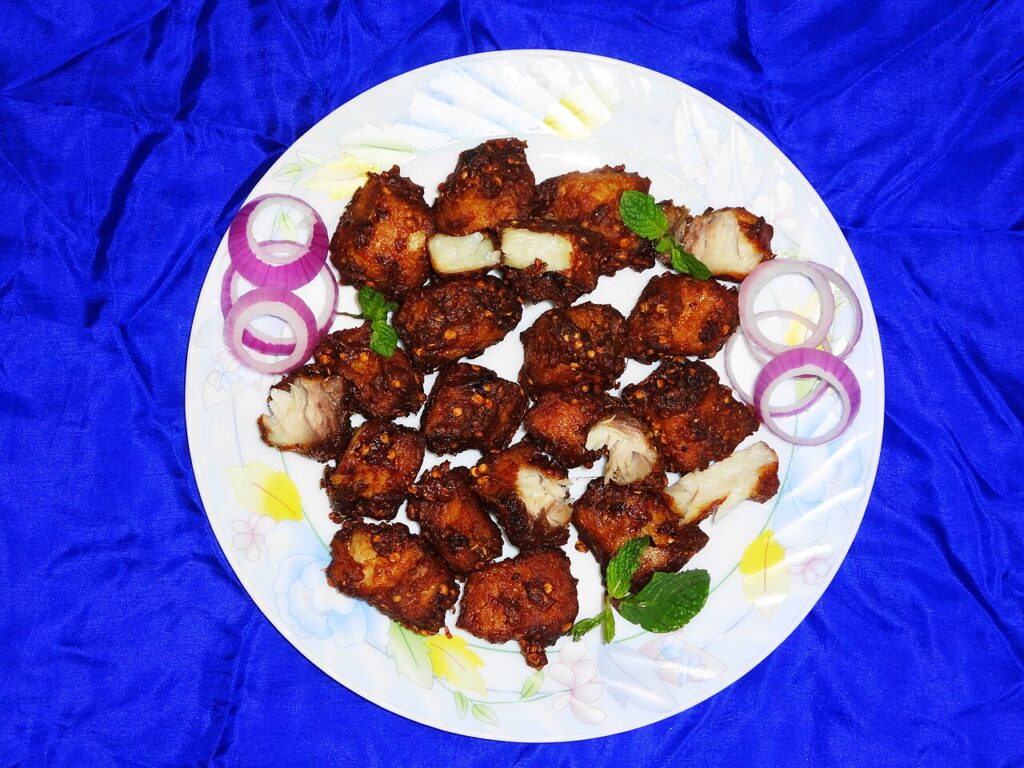 A plate of Lahori fried fish with onions and lemon