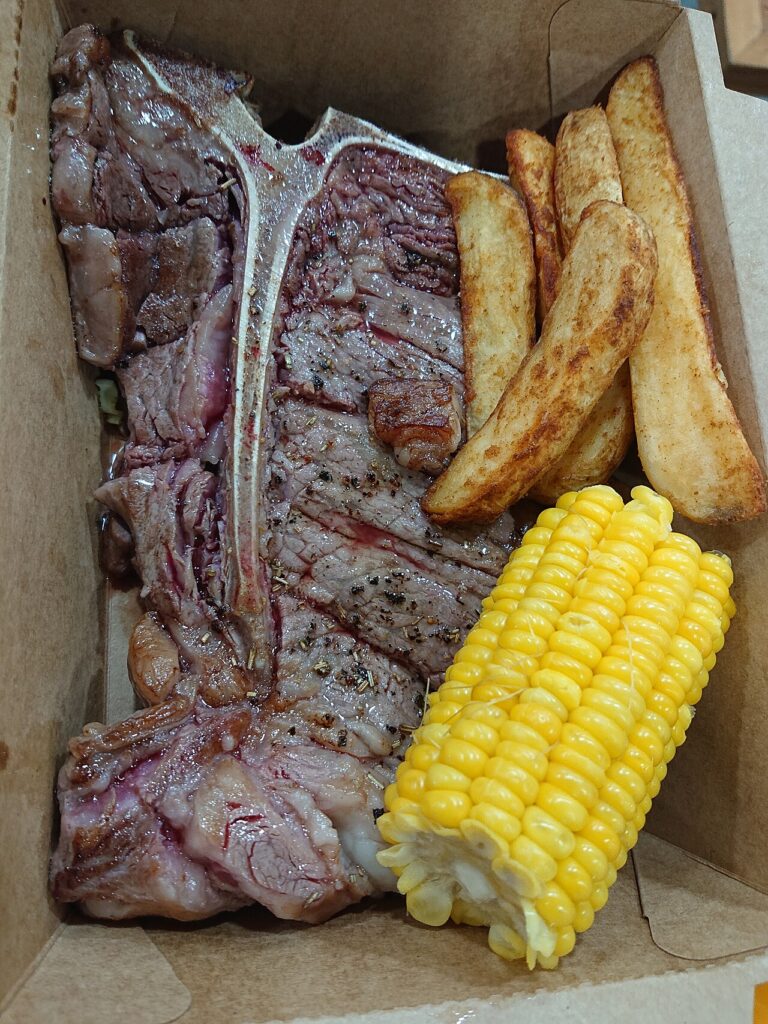 T-bone steak served with corn and fries